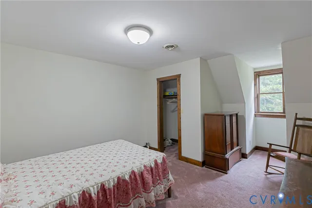 a bedroom with a bed and a refrigerator