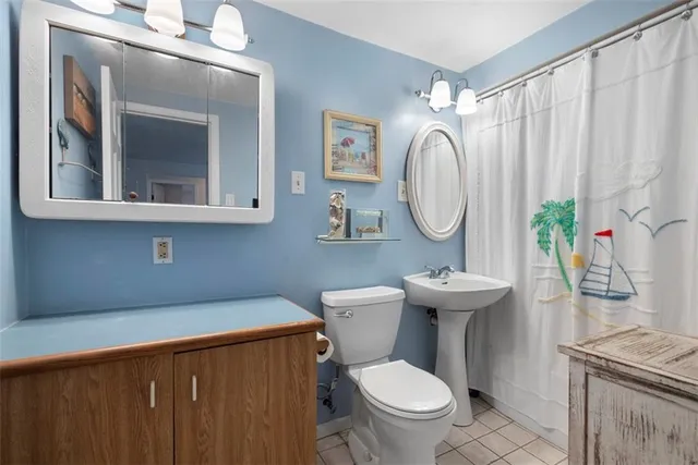 a bathroom with a toilet a sink and a mirror