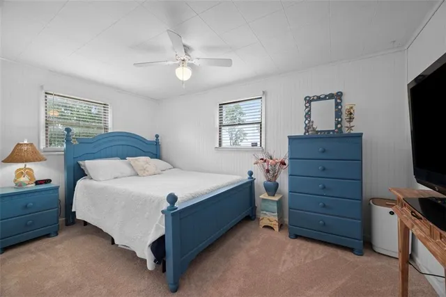a bedroom with a bed and a tv on the dresser