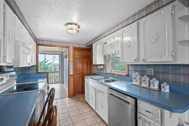 a kitchen with stainless steel appliances granite countertop a sink stove and cabinets