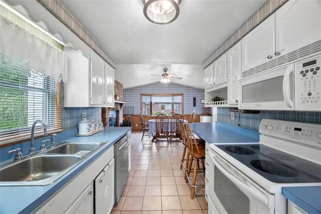 a kitchen with stainless steel appliances granite countertop a sink a stove and a refrigerator