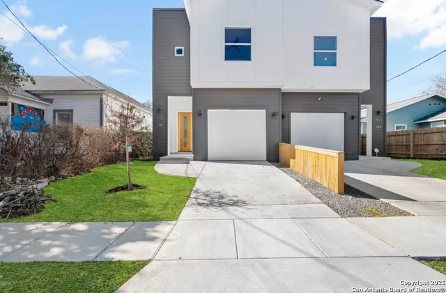 a front view of a house with a yard and trees