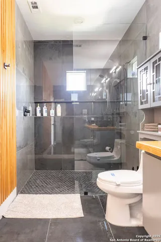 a bathroom with a toilet and a shower