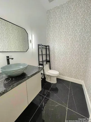 a bathroom with a granite countertop sink and a mirror