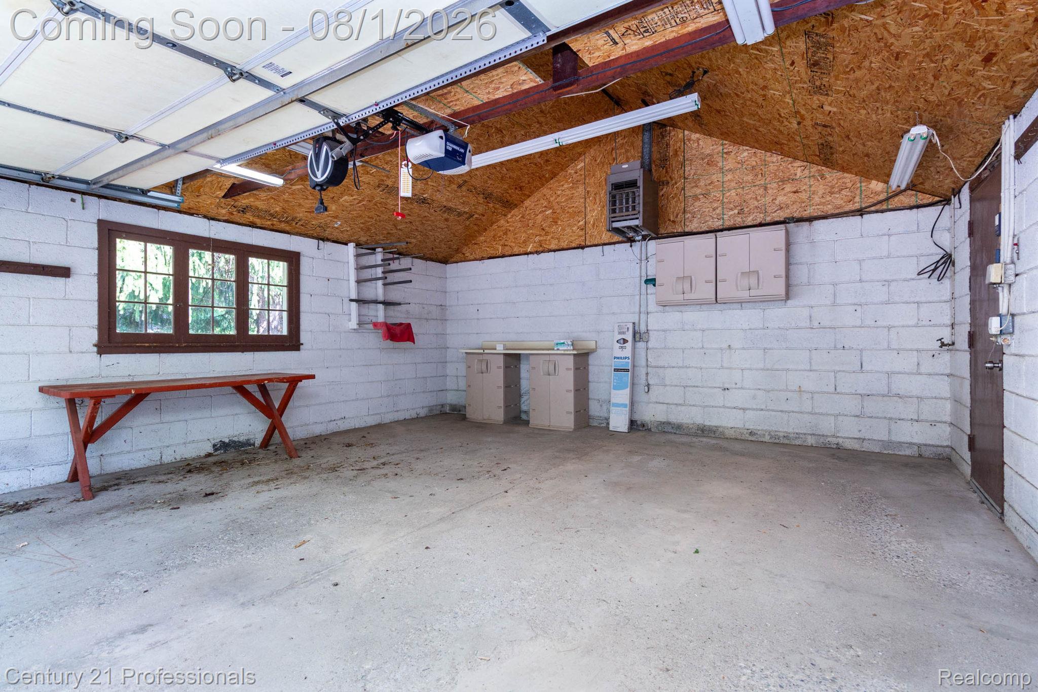 1365 East Buell Road Rochester, MI 48306 - Photo 25 of 56 Spacious garage featuring concrete block walls, exposed wood ceiling, a window with dark wood trim, and a utility sink area