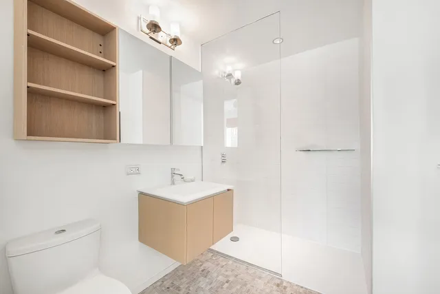 a bathroom with a sink a toilet and shower