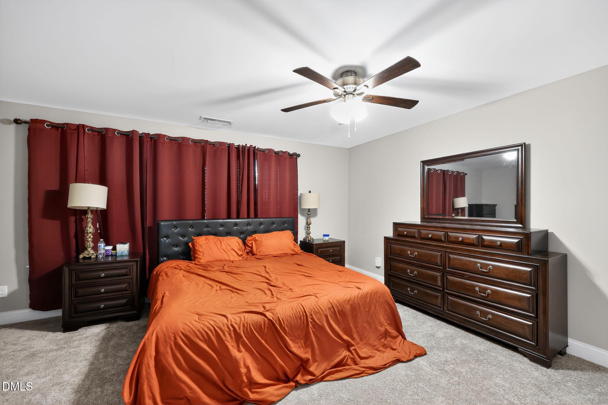 5721 Princess Curry Way Raleigh, NC 27610 - Photo 18 of 29 a bedroom with a bed and a chandelier