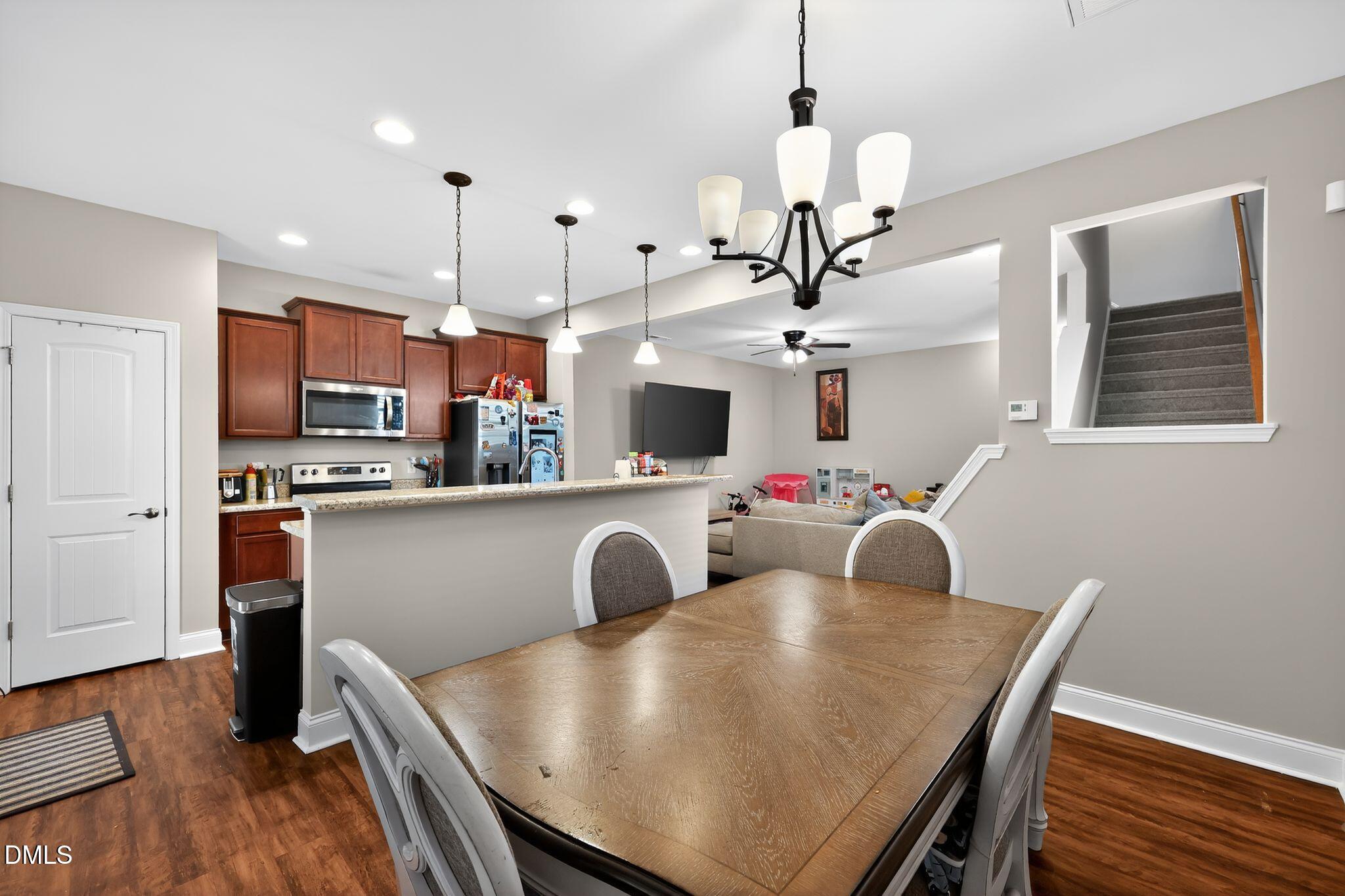 5721 Princess Curry Way Raleigh, NC 27610 - Photo 10 of 29 a kitchen with kitchen island a dining table chairs stainless steel appliances and cabinets