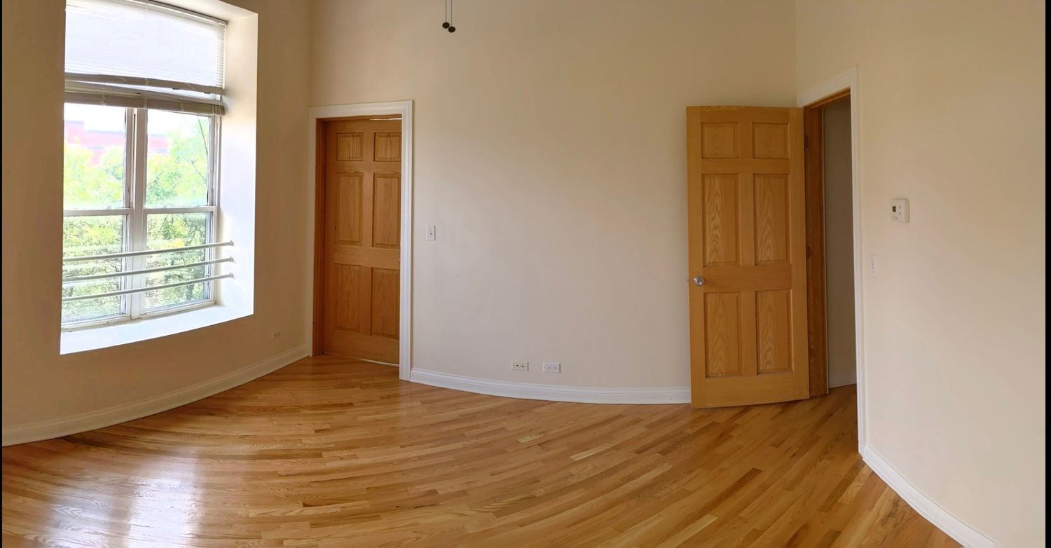 1100 West Taylor Street, Unit 3F Chicago, IL 60607 - Photo 5 of 9 a view of an empty room with wooden floor and a window