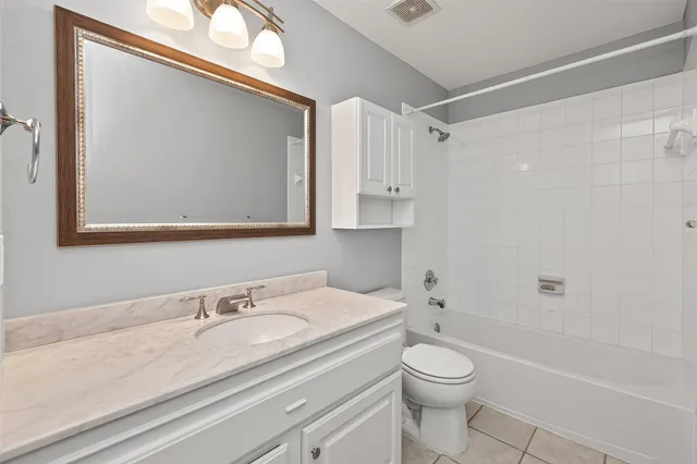 a bathroom with a granite countertop sink a toilet and a mirror