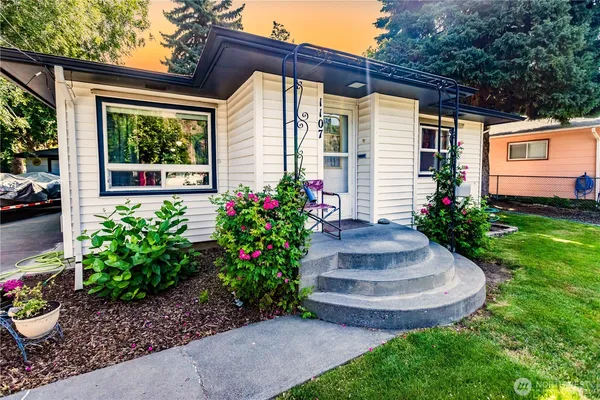 a view of a house with a yard and a garden