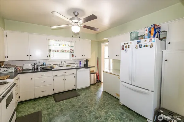 a kitchen with granite countertop cabinets and white appliances