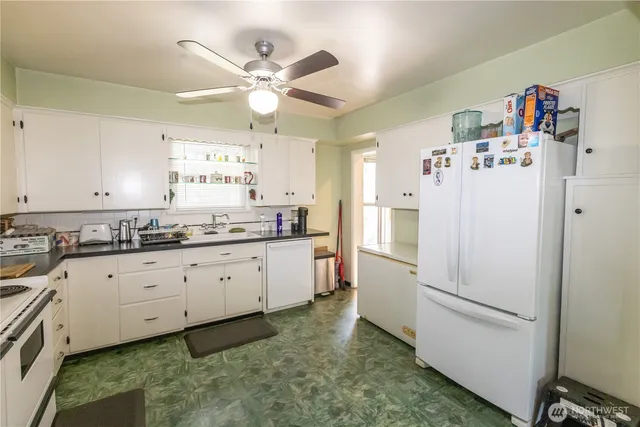 a kitchen with granite countertop cabinets and white appliances