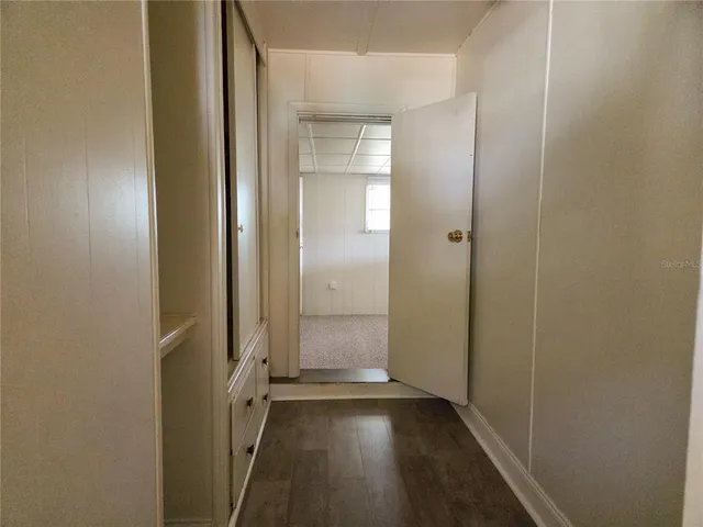 an empty room with wooden floor and entrance