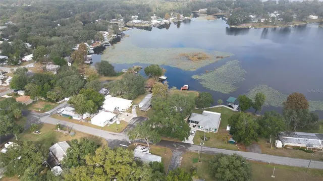 an aerial view of a house with a yard and lake view