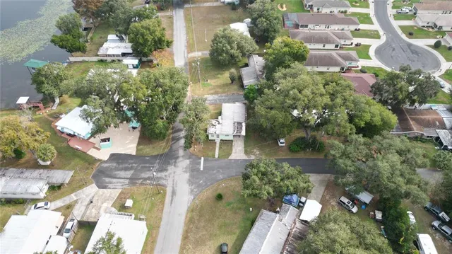 an aerial view of a house with a yard and lake view