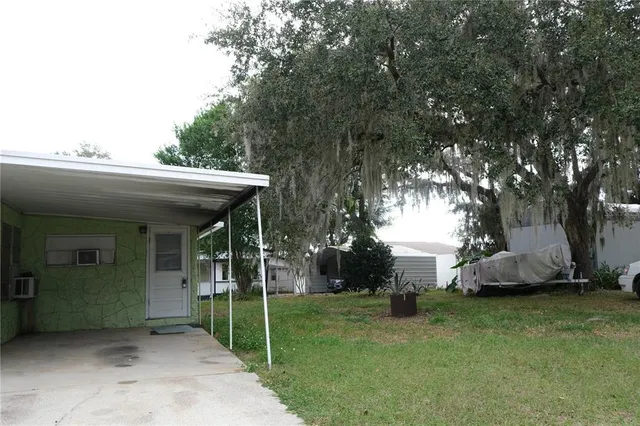 a view of a house with backyard and a tree