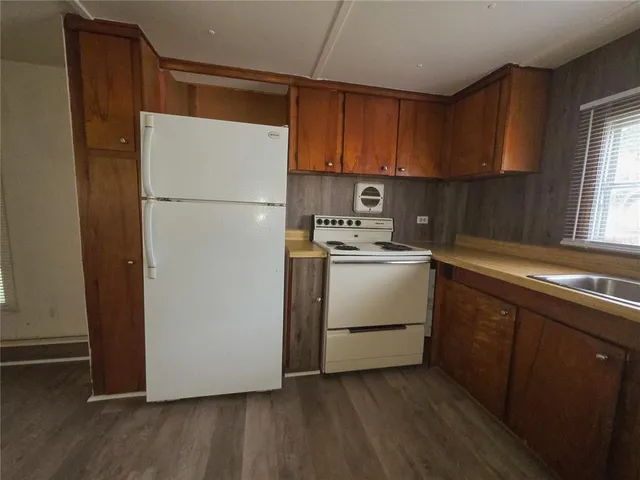 a kitchen with a refrigerator sink and cabinets