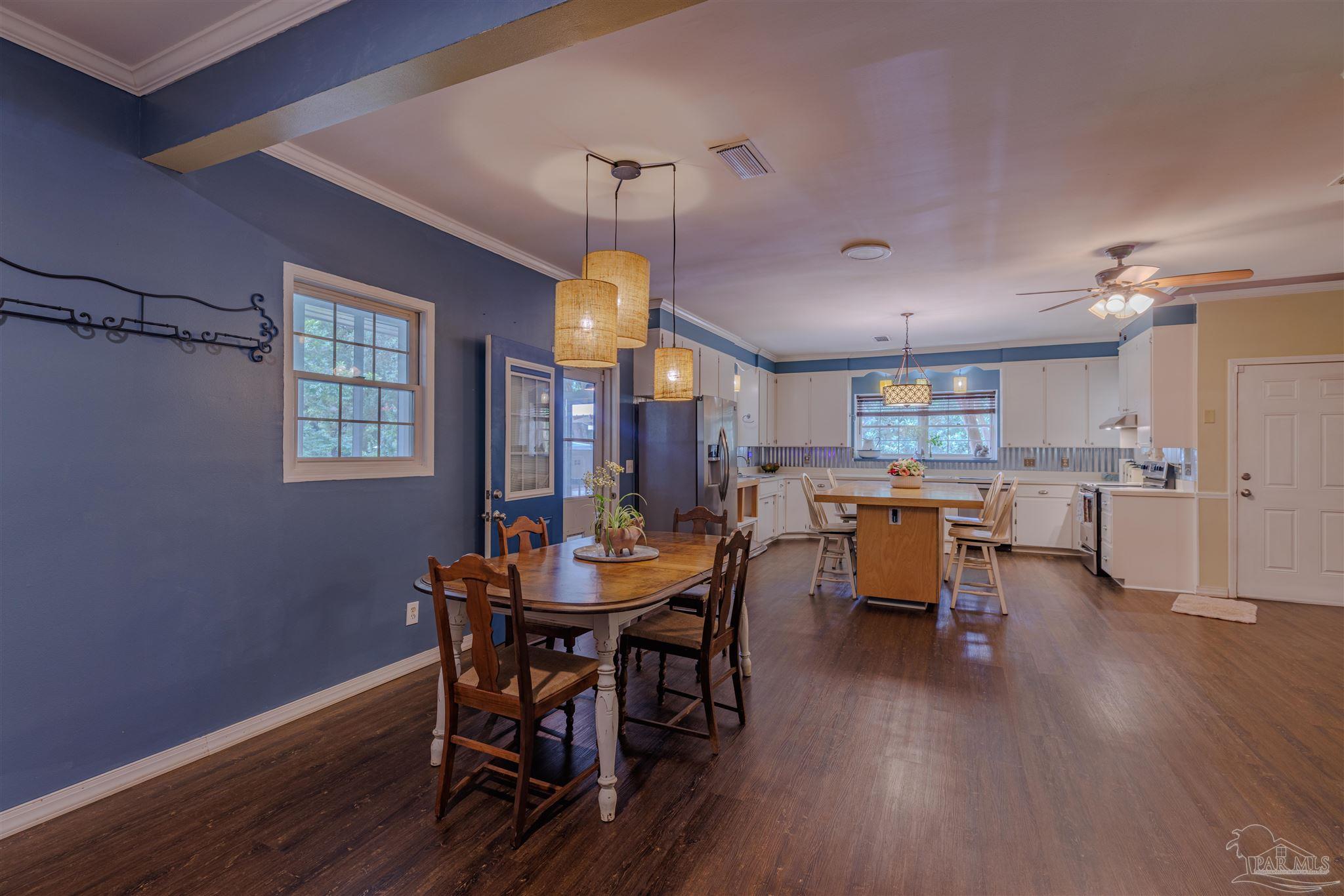 5049 Guernsey Road Pace, FL 32571 - Photo 29 of 61 a view of a dining room with furniture and wooden floor
