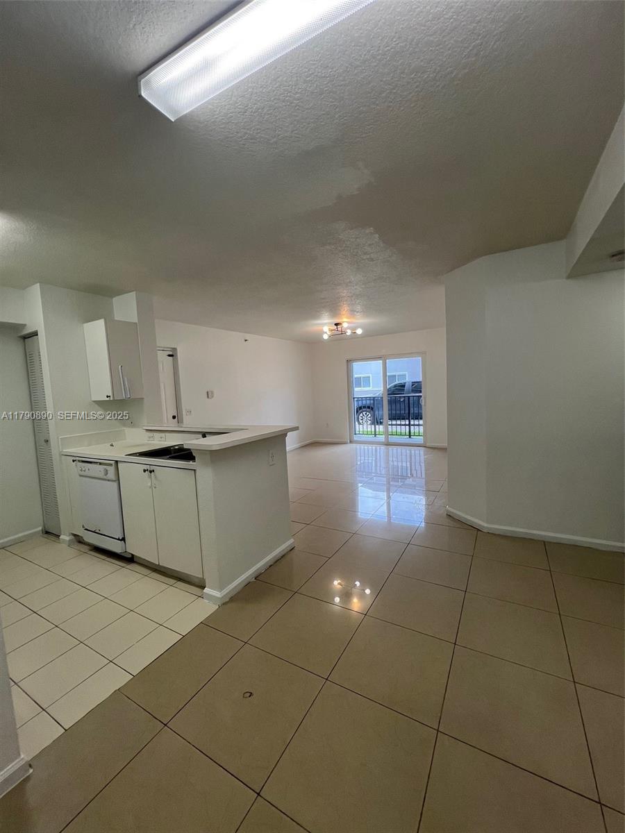 15422 Southwest 284th Street, Unit 7104 Homestead, FL 33033 - Photo 23 of 31 a kitchen with stainless steel appliances a sink a stove a microwave and cabinets