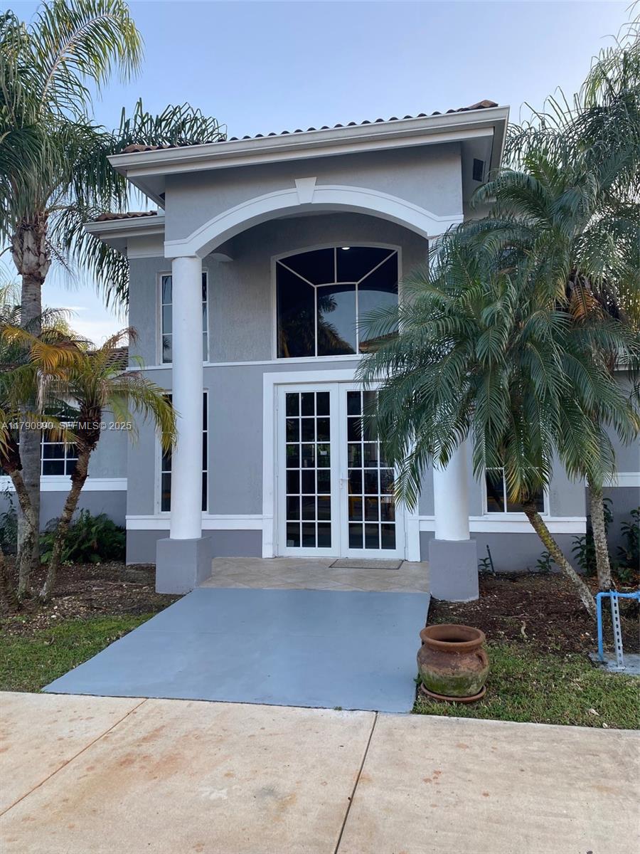 15422 Southwest 284th Street, Unit 7104 Homestead, FL 33033 - Photo 26 of 31 a front view of a house with a garden