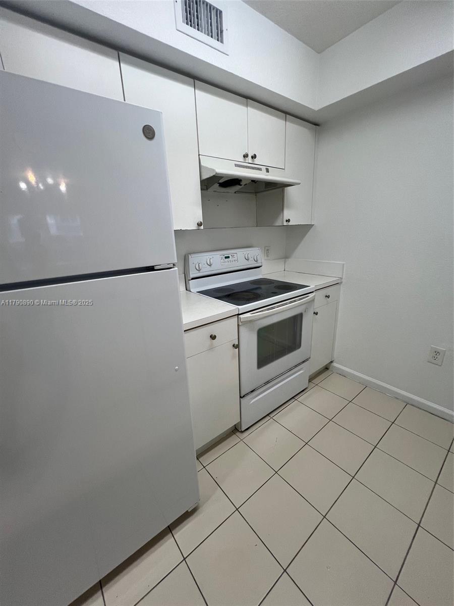 15422 Southwest 284th Street, Unit 7104 Homestead, FL 33033 - Photo 9 of 31 a kitchen with a stove and a refrigerator