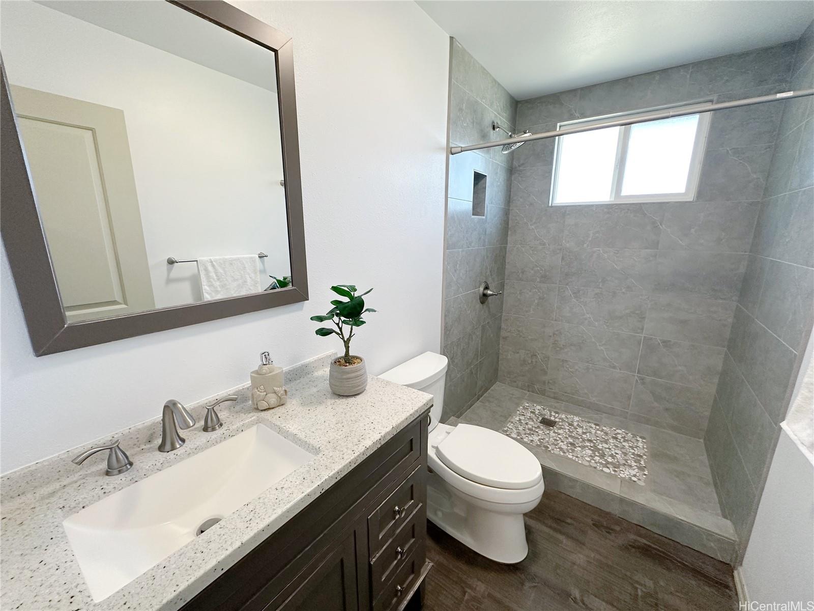 2578 Pacific Heights Road Honolulu, HI 96813 - Photo 13 of 25 a bathroom with a granite countertop toilet a sink and a mirror