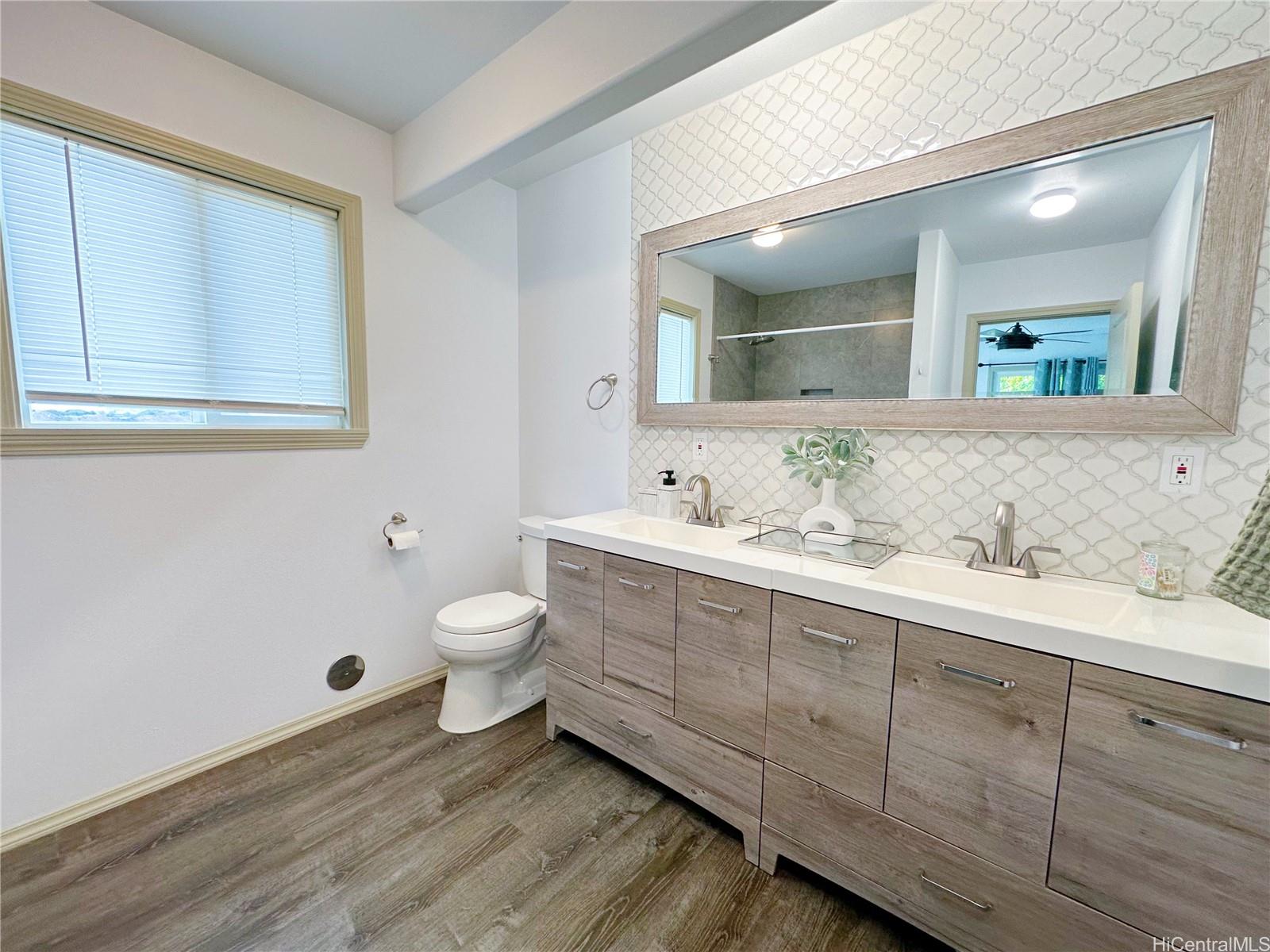 2578 Pacific Heights Road Honolulu, HI 96813 - Photo 9 of 25 a bathroom with a granite countertop toilet a sink and a mirror