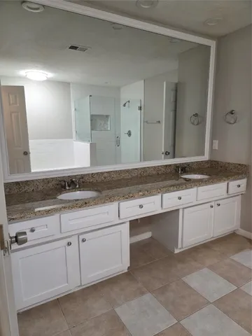 a bathroom with a granite countertop sink and white