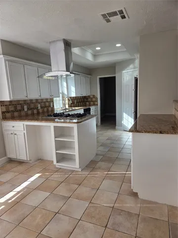 a kitchen with kitchen island granite countertop a stove a sink and a refrigerator