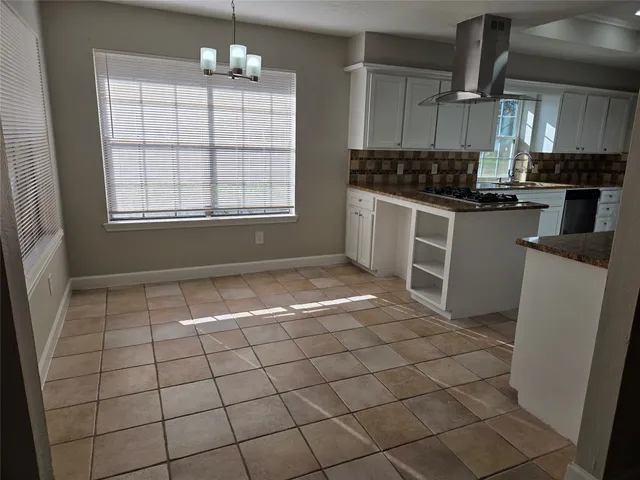 a kitchen with granite countertop a stove a sink and a refrigerator