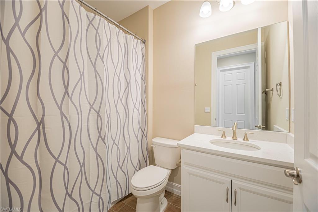 1003 Enbrook Loop Naples, FL 34114 - Photo 12 of 20 a bathroom with a granite countertop sink and a toilet