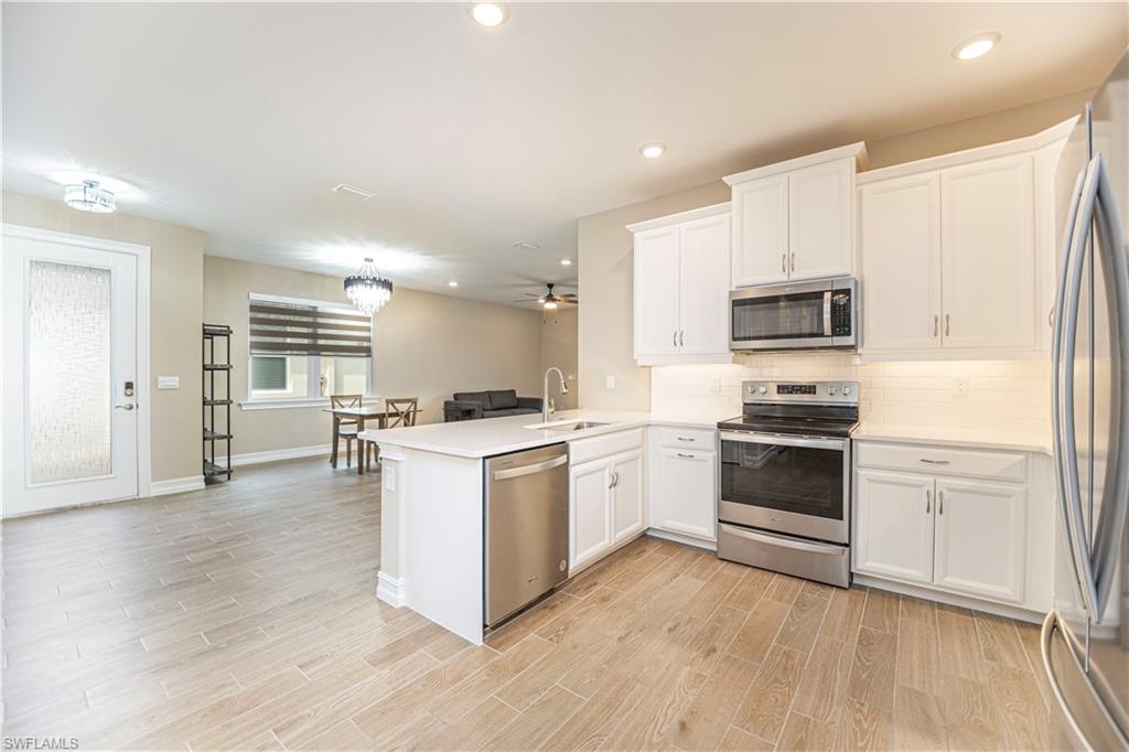 1003 Enbrook Loop Naples, FL 34114 - Photo 13 of 20 a kitchen with stove cabinets and refrigerator