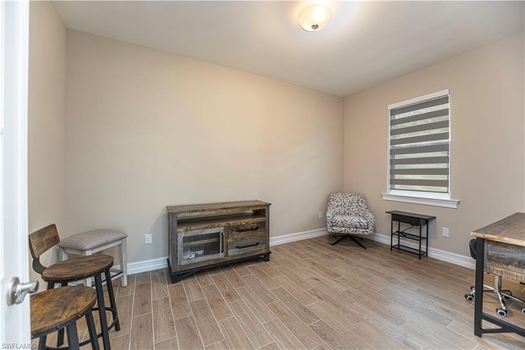 1003 Enbrook Loop Naples, FL 34114 - Photo 14 of 20 a room with furniture and a wooden floor