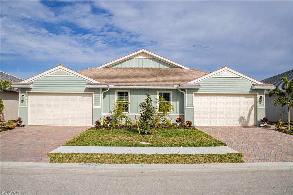 1003 Enbrook Loop Naples, FL 34114 - Photo 2 of 20 a front view of a house with a yard table and chairs