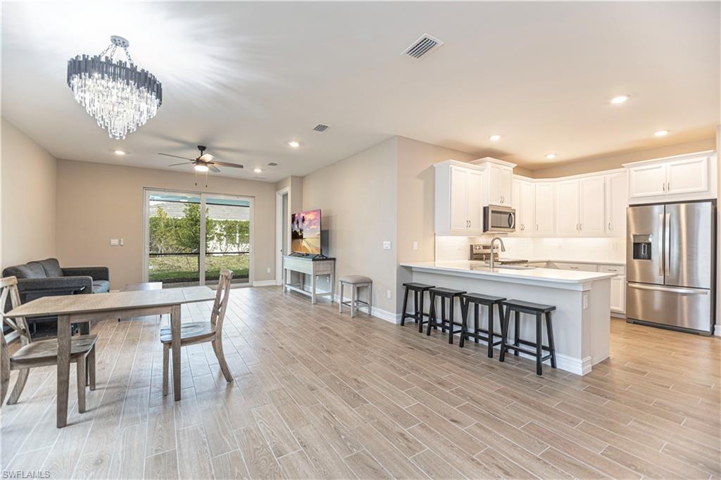 1003 Enbrook Loop Naples, FL 34114 - Photo 8 of 20 a view of a dining room with furniture window and wooden floor