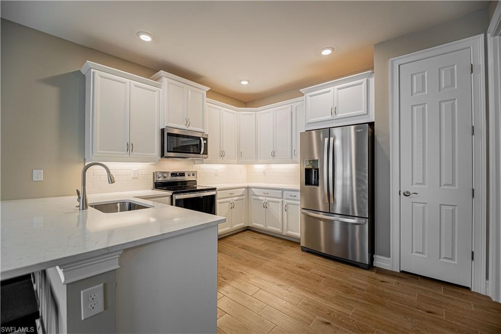 1003 Enbrook Loop Naples, FL 34114 - Photo 10 of 20 a kitchen with a refrigerator sink and microwave