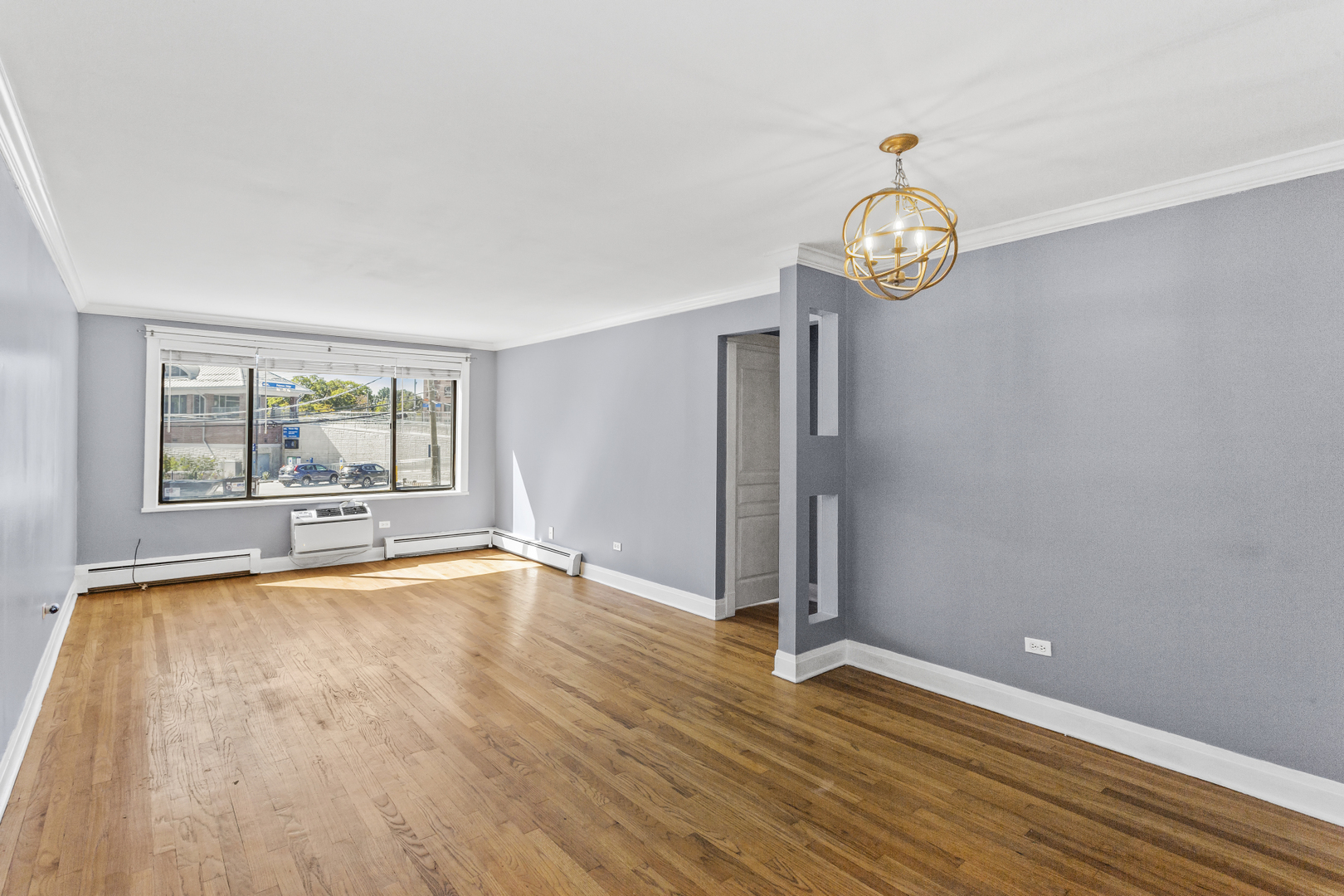 6060 North Ridge Avenue, Unit 2H Chicago, IL 60660 - Photo 2 of 23 a view of an empty room with wooden floor and a window