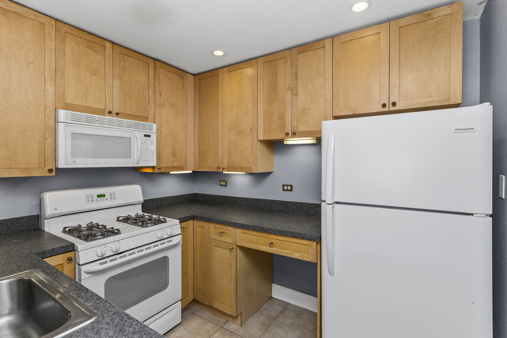 6060 North Ridge Avenue, Unit 2H Chicago, IL 60660 - Photo 8 of 23 a kitchen with a refrigerator a stove a sink and cabinets