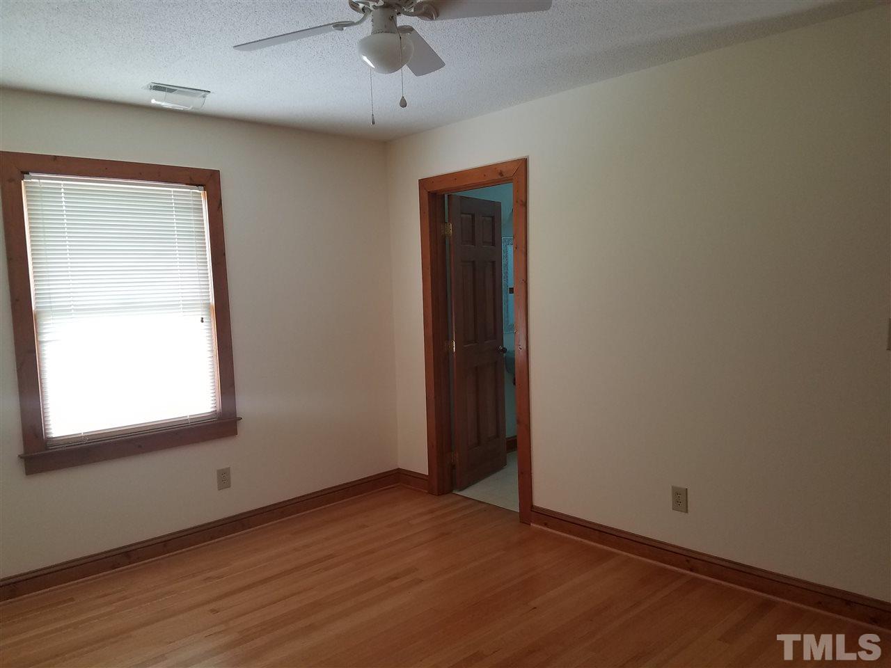 1012 Reca Road Garner, NC 27529 - Photo 14 of 23 an empty room with a window and wooden floor