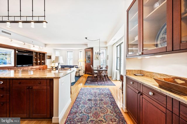 a kitchen with stainless steel appliances kitchen island granite countertop a sink and a refrigerator
