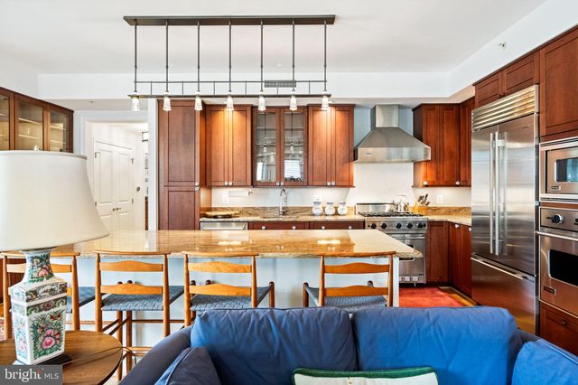a kitchen with stainless steel appliances granite countertop a sink and a refrigerator