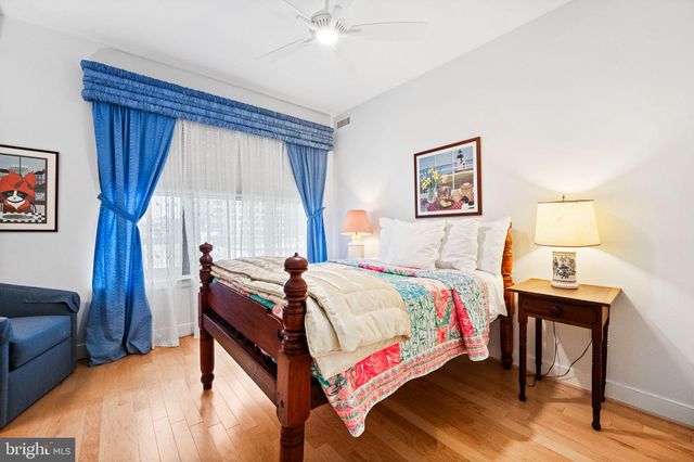 a bed sitting in a spacious bedroom next to a window
