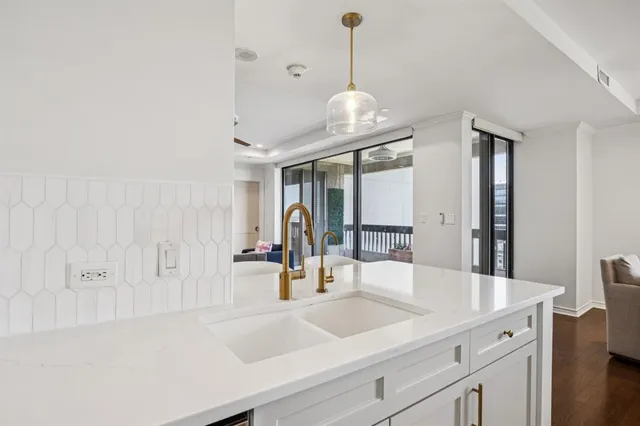 a view of kitchen island a sink and wooden floor