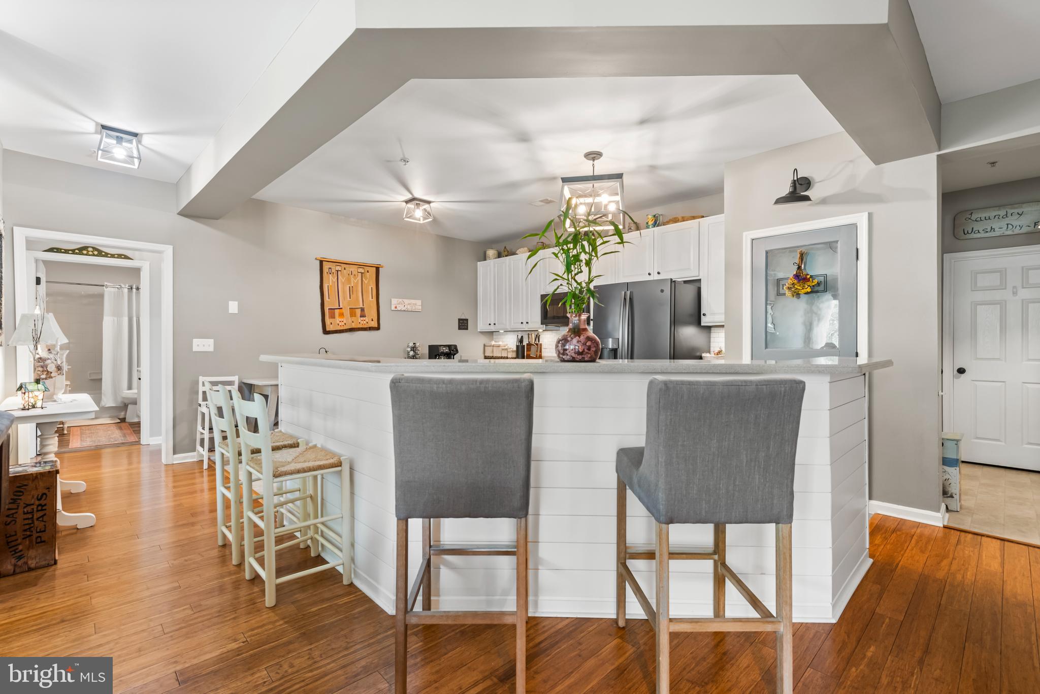 900 Marshy Cove, Unit 103 Cambridge, MD 21613 - Photo 2 of 19 a dining room with kitchen island stainless steel appliances furniture a dining table and chairs