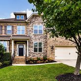 a front view of a house with a garden and yard
