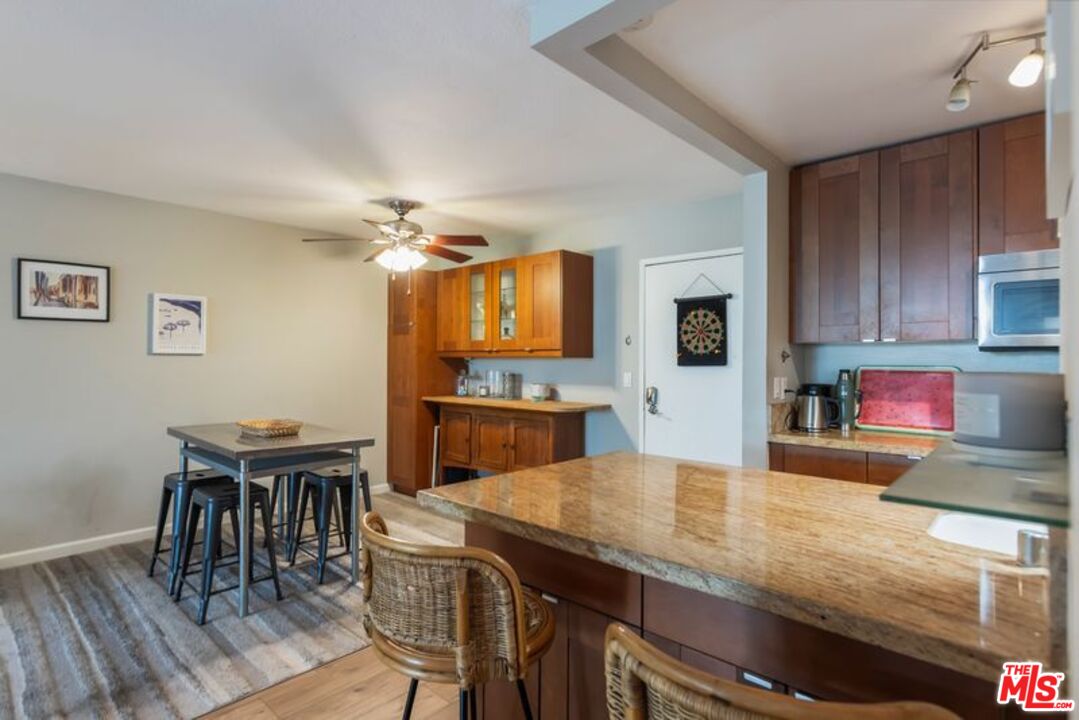 7765 West 91st Street, Unit A2117 Playa del Rey, CA 90293 - Photo 7 of 27 a kitchen with granite countertop kitchen island wooden floor and stainless steel appliances