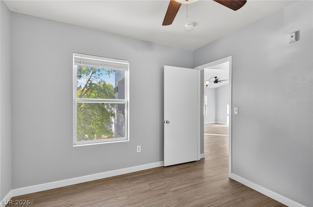 7255 West Sunset Road, Unit 2144 Las Vegas, NV 89113 - Photo 13 of 23 Empty room with wood finished floors and a ceiling fan