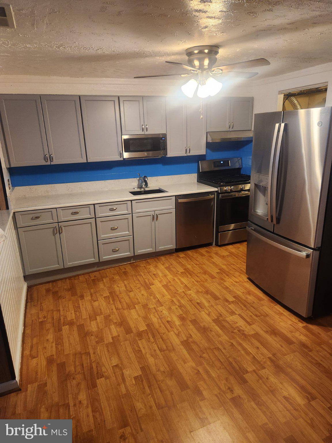 2760 Yarnall Road Baltimore, MD 21227 - Photo 8 of 22 a kitchen with granite countertop a refrigerator and a stove top oven