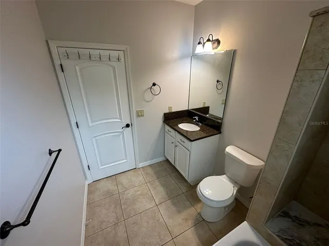 a bathroom with a toilet a sink a vanity and mirror